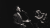 Bradley Jago singing into a microphone on stage alongside two backing vocalists.