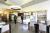 A café with tables, chairs a food counter and a drinks fridge