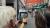 Two participants look at a historical street photograph displayed on a tablet during the event in London’s Chinatown, with red lanterns hanging above the street.