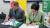 Two colleagues signing memoranda of agreements. In front of them are the UK and Uzbekistan flags.
