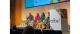Four people sitting on a stage talking to an audience 