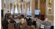 People sitting around tables listening to a speaker