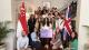 A group of students in Singapore for Westminster Working Cultures initiative surrounded by Singapore and Great British flags.