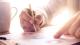 Close up picture of a businessman studying a report with a cup of coffee on the side, Image by PureSolution