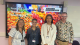 Professor Dr Emily Falconer, PhD researchers Mariam Selim and Yumeng Yung, and Professor Dr Daniel Conway standing together in front of a screen displaying colourful fruit and vegetables and the text “Food and Taste Studies at Westminster.”