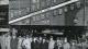 Image showing a group of 14 men and one woman standing in front of a train carriage with a sign reading "Gratitude train"