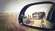 Small farmhouse reflection in rear car mirror