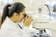 A woman looking through a microscope