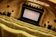 A large cinema screen with cinema chairs