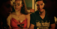 A woman and a man at a social gathering holding beverages