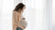 Pregnant woman holding stomach 