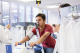 A man working out on a bicycle whilst being tested by someone in a white coat