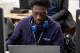 Student in purple hoodie browsing on laptop
