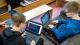 Two vulnerable people sitting down and using laptops