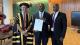 Professor Peter Bonfield in his academic robes with Yaw Addo and Godfried Addo. Yaw is holding his father's honorary doctorate certificate.