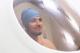 An athlete sitting in the BodPod chamber - a pod with a glass window. The athlete is smiling.