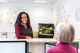 Image of a woman smiling over a reception desk