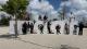 Students sat on a large sign reading maat outside the Lisbon Museum of Art, Architecture and Technology (MAAT)