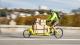 Man riding cargo bike on road with cardboard boxes attached