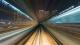 Blurred lights of a train moving fast against a cityscape at night.