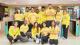 A diverse group of thirteen student ambassadors, wearing yellow University of Westminster branded clothing