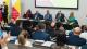 Photo of panellists on the welcome address panel. The panellists and audience are clapping.
