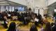 Students watching a presentation where they get to understand the willow fabrics provided by Stradling. In the foreground there are willow branches which will be used in the students' designs.