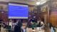 Attendees discuss questions about gender, tourism and climate change. Starter questions appear on a projector.