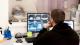 Photo of a man looking at MR images on a computer screen.