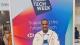 Photo of Semir Idris in front of a poster reading "London Tech Week"