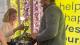 Student collecting vegetables from the hydroponic wall with help from an instructor.