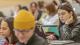 Student in a lecture theatre on a laptop.