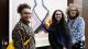 Students Amy Grant and Grace Harrington stand in front of Grace's work, which is a crochet top, with Professor Pippa Catterall.