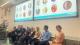 Photo of the panel at the Suicide Prevention Day conference. Behind them are screens showing headshots of the panellists.