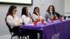 Panel speakers at the What Comes Next? Sociology and Criminology event sat on a table with a purple tablecloth. White text on the tablecloth reads ALUMNI UNIVERSITY OF WESTMINSTER