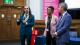 Dibyesh Anand, Deborah Husbands and Peter Bonfield stand at the front of the room welcoming attendees.