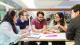 Picture of five Westminster students sat at a table chatting and smiling