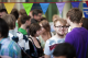 male student smiling at camera, surrounded by other students, and colourful bunting above him.