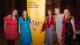 WS team Emma Waslin (left), founder Bee Rowlatt (second right) and trustee and Westminster governor Caron Bradshaw (right) with Laura Bates (centre left) and Gemma Cairney (centre right) stand in front of a yellow banner with the word Mary in purple and the text "Advancing Human Rights Through Education and Engagement" at the top in black.