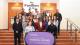 Westminster students standing with Levi Roots behind a purple banner that reads WESTMINSTER WORKING CULTURES