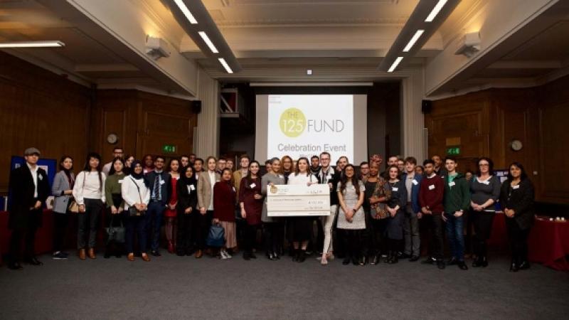 A group of students holding a cheque