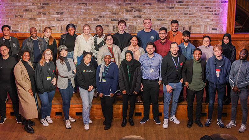 A group of Westminster students and graduates pictured at WeNetwork event in-front of the stage