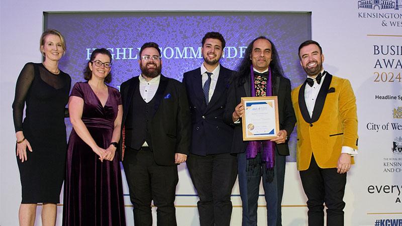 Linsey Cole, an alumni representative, a student representative and Professor Dibyesh Anand stand with representatives from the KCW Business Awards team in front of a screen that reads HIGHLY COMMENDED. Professor Anand holds Westminster's certificate.