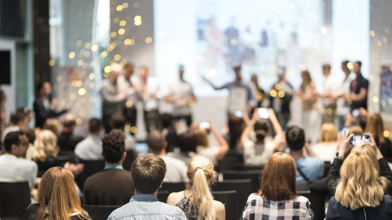 Awards ceremony with an audience and gold confetti on the stage