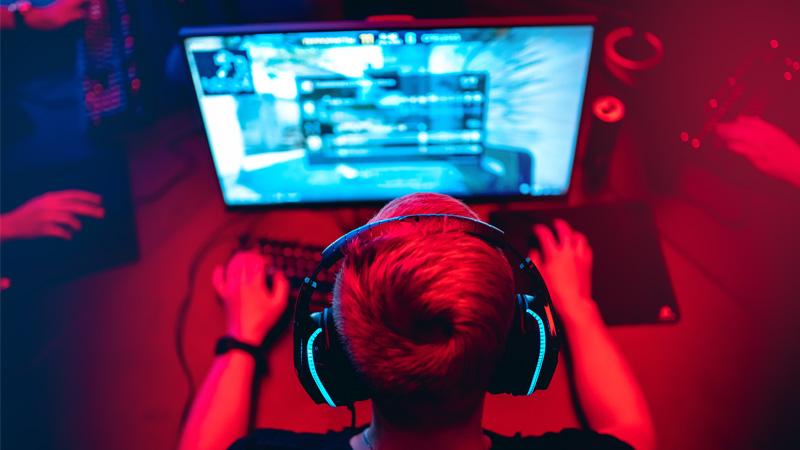 Boy playing a computer game with headphones on