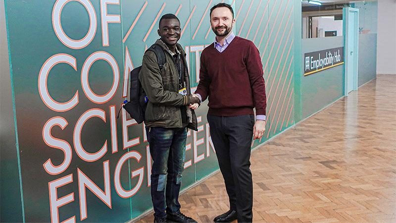 Dr Christian Dennys-McClure and Felix Fomengia at Cavendish Campus shaking hands