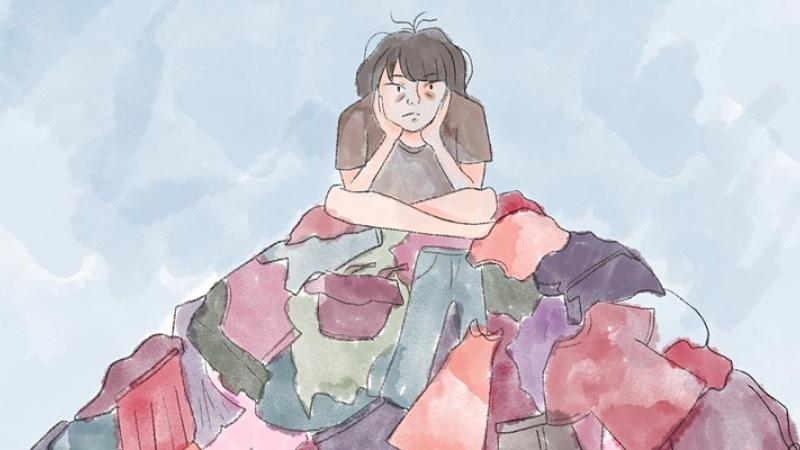 girl sat on montain of clothes