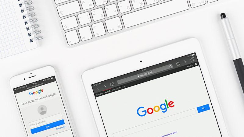 Google web page on display of iPad and iPhone