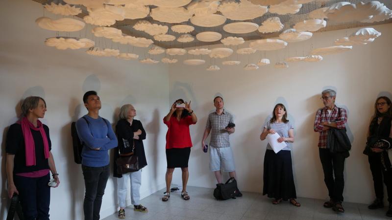 A white room with art hanging from the ceiling.