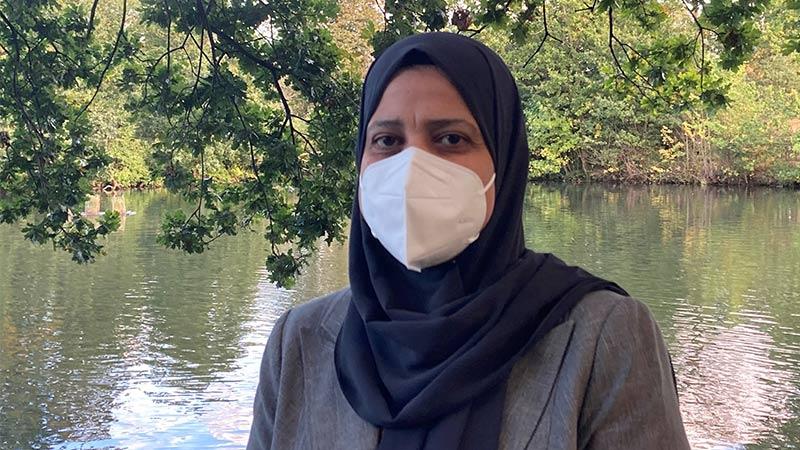 Image of Manal Mohammed with a tree and a lake in the background